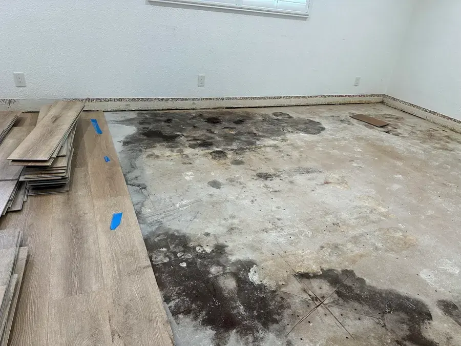 Plank flooring pulled up over a wet subfloor during water damage restoration in Lancaster