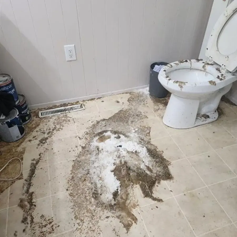 Sewage debris spread across a bathroom floor around a toilet after a backup in Lancaster, SC